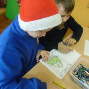 Dzieci kolorują obrazek przedstawiający choinkę